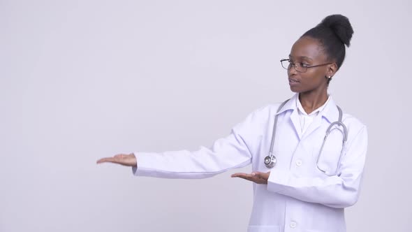 Young Happy African Woman Doctor Showing Something
