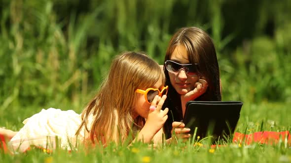 Picnic. Mother With Daughter Using Tablet Outdoor