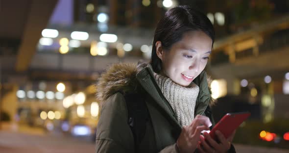 Woman using mobile phone at night