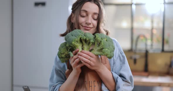 Housewife Enjoying Fresh Broccoli While Cooking