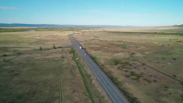 Aerial View of an Intercity Asphalt Road in Rural Area Road Between Fields with Rare Trees