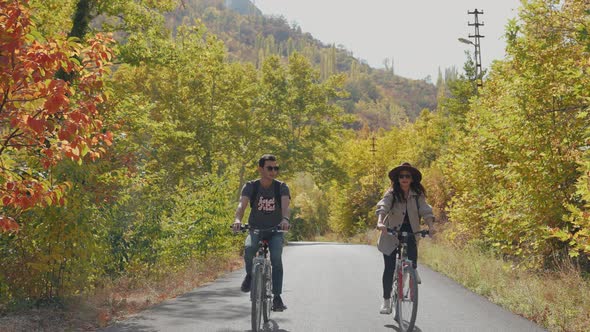 Traveller Couple Riding Bikes In Summer Forest