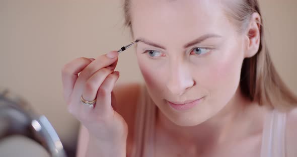 Woman Doing Makeup Painting Eyelashes with Mascara