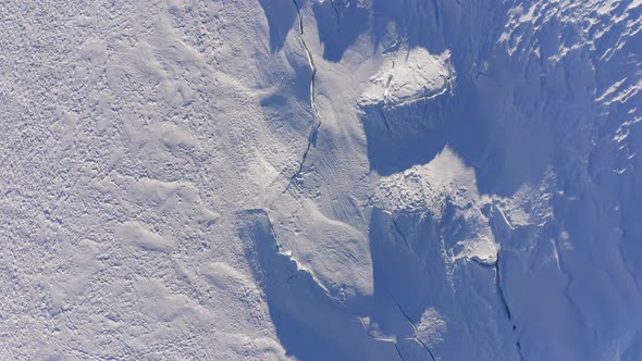 Top View Aerial Over Glacier Covered in Snow Wirh Clefts and Rifts. Winterland Outdoor Establisher