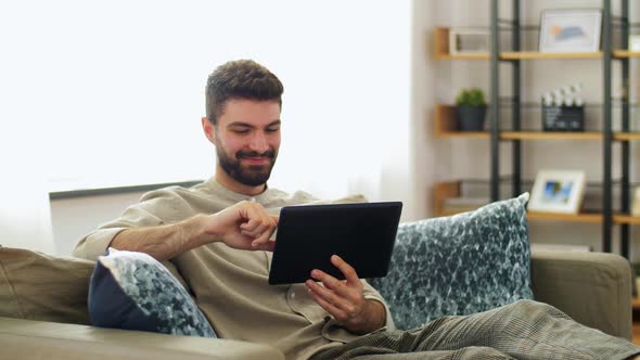 Smiling Man with Tablet Computer at Home