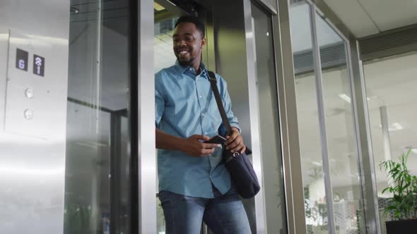 Video of happy diverse woman and man walking outside elevator and talking