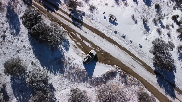 Car parked at snow covered rest stop in Colorado during the winter, aerial top down
