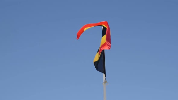 Belgium flag  tricolour stripes against blue sky close-up  slow-mo 1080p FullHD footage - Slow motio