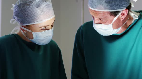 Surgeons interacting with eachother while performing operation in operation room