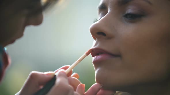 Inspired Makeup Artist Applying Lip Gloss, Preparing Beautiful Bride for Wedding