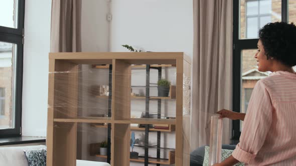 Happy Woman Packing Shelf and Moving to New Home