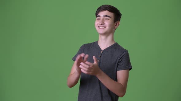 Young Handsome Iranian Teenage Boy Against Green Background