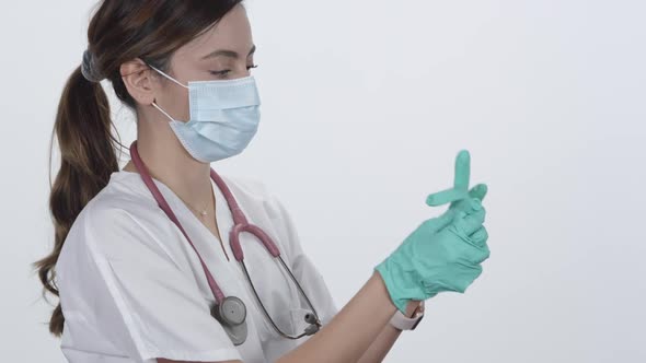Nurse putting on rubber glove with index finger in the air