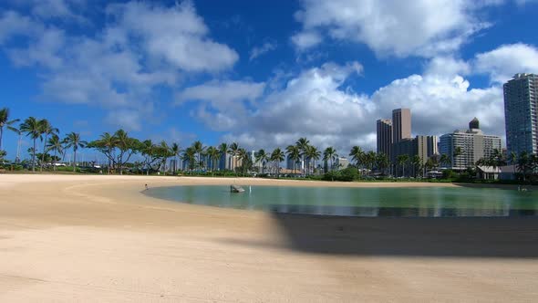 Beautiful footage of a quiet sandy bay surrounded by hotels on a sunny day in Hawaii