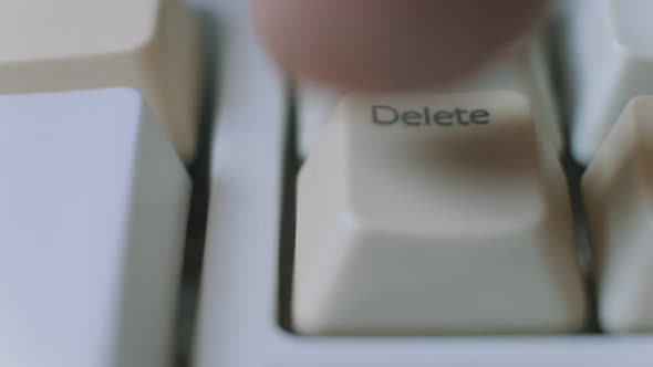 Close-up Shoot of Human Finger Repeatedly Pressing the Delete Key on a Keyboard.