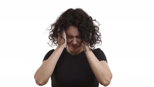 Attractive Adult Woman with Short Curly Hair Wearing Black Tshirt Grimacing and Looking Distressed