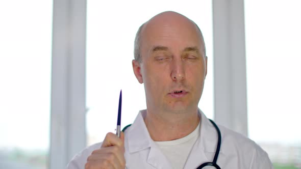 Serious Male Doctor in White Coat Explaining Diagnosis and Looking at Camera