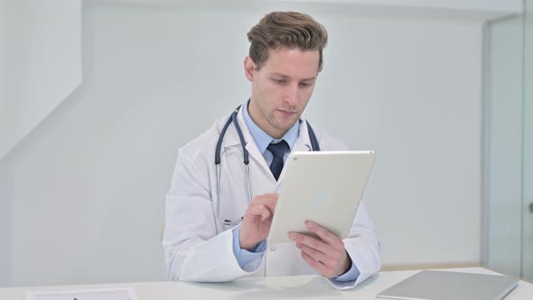 Hardworking Young Male Doctor Using Tablet in Modern Office