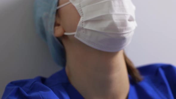 Tired Doctor or Nurse in Face Mask Taking Hat Off