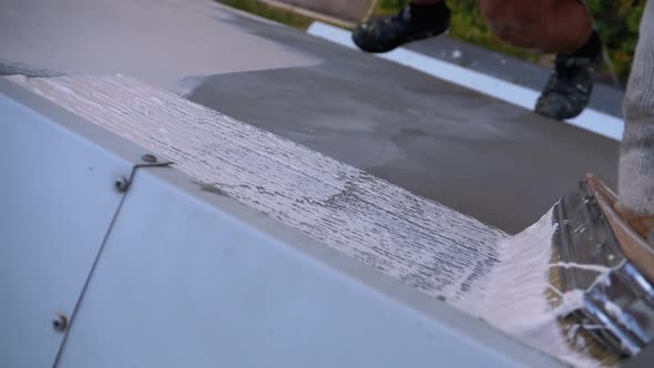 Industrial Climber Paints Wall of Facade with White Paint Using Paintbrush. Slow Motion