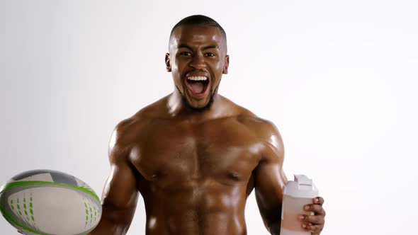 American football player holding a water bottle and rugby ball