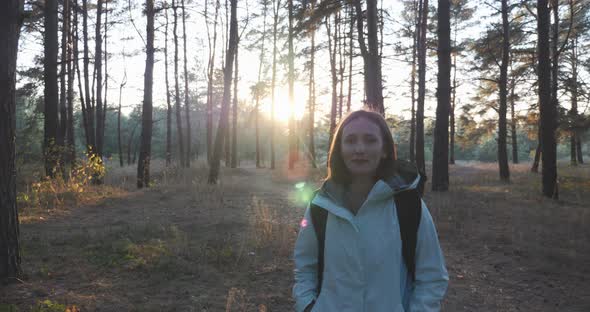 Woman is walking in forest in sunlights