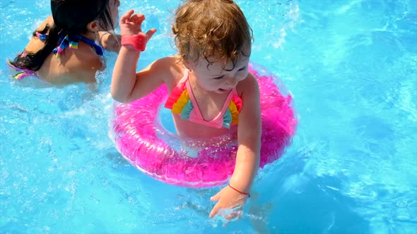 A Child Swims in a Pool with a Circle