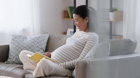 Happy Pregnant Woman Reading Book at Home