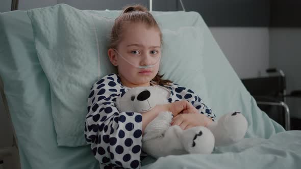 Portrait of Little Girl Patient Wearing Oxygen Nasal Tube Resting in Bed Recovery