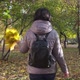 A Brunette Woman in a Brown Jacket and a Bouquet of Leaves Is Walking in the Park - VideoHive Item for Sale