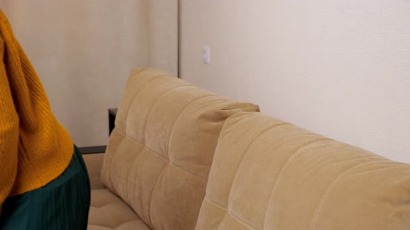 Depressed Brunette with Long Loose Flowing Hair Sits on Sofa