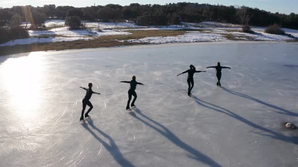 Group of young women firgure skating on frozen lake