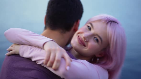 Closeup Happy Beautiful Young Woman with Pink Hair Hugging Man with Blue River Water Waves at