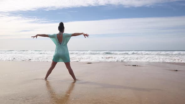 Authentic shot of woman alone at seaside facing waves splashing