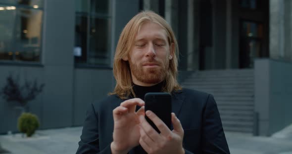 Crop View of Handsome Businessman in 30s Smiling While Using phone, Successful Man with Long Hair 