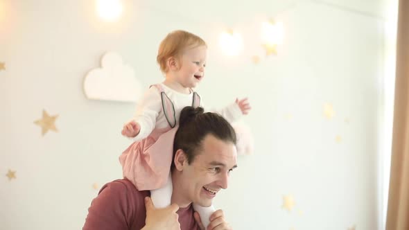 Happy Dad Rolls His Little Daughter on His Neck