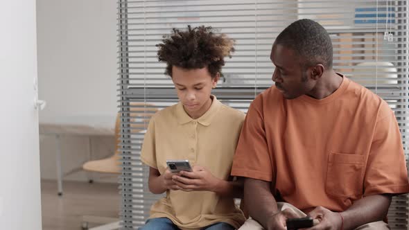 African Man and Boy Talking Indoors