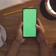 Top View Woman Uses Thumb Touch On Green Screen Of Smart Phone. Hobby Table Background. Chroma Key. - VideoHive Item for Sale