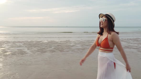 cheerful woman in bikini walking on the sea beach