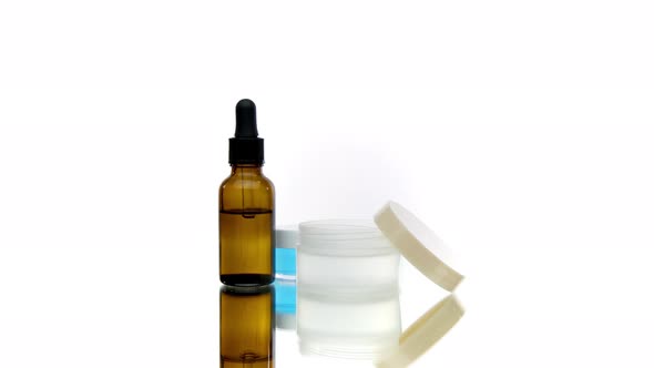 Set of Three Bottles and Jars with Cosmetics, Transparent Gels and Drops
