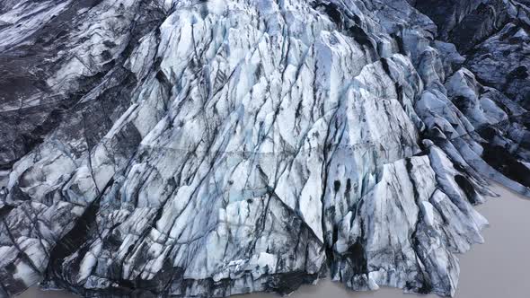 Aerial View of Solheimajokull Glacier, Iceland. Crevasse and Black Volcanic Ash Captured in the Ice