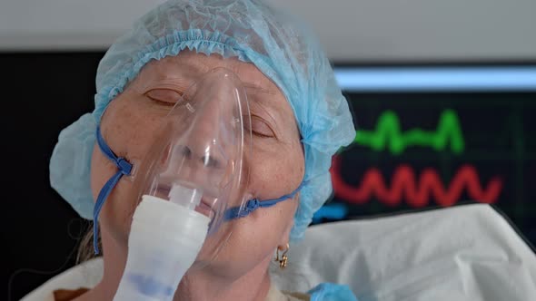 Portrait of Old Dying Woman with Closed Eyes in Oxygen Mask on Hospital Bed