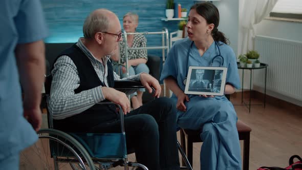 Woman Nurse with x Ray on Tablet Showing Scan to Old Patient