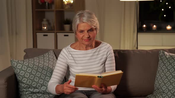 Senior Woman Reading Book and Drinking Tea at Home