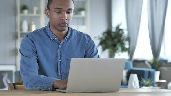 Young African Man Coming to Work on Laptop