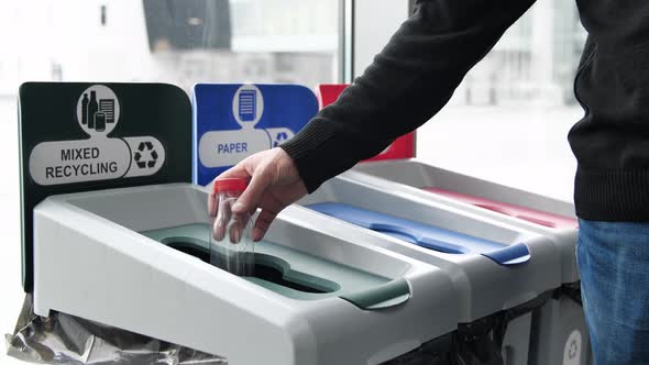 Throwing empty bottle in waste separation trash bins