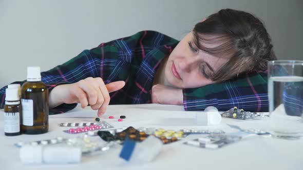 Upset Woman with Some Pills on a Table