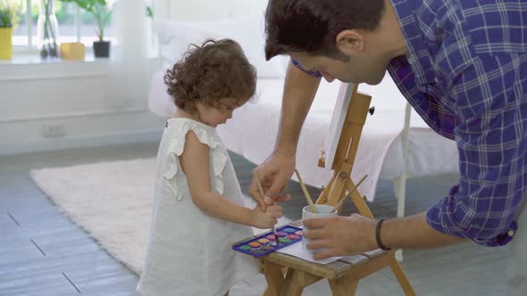 Happy family of father and kid drawing picture, using different paints and brushes, Lesson of art.