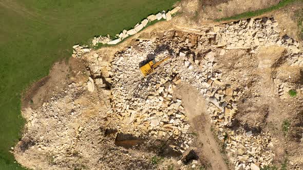 Flying Above an Excavator Working in a Limestone Quarry