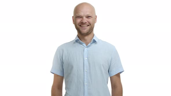 Young Middleaged Bald Guy with Bristle Wearing Blue Casual Shirt Laughing and Smiling Happy Looking